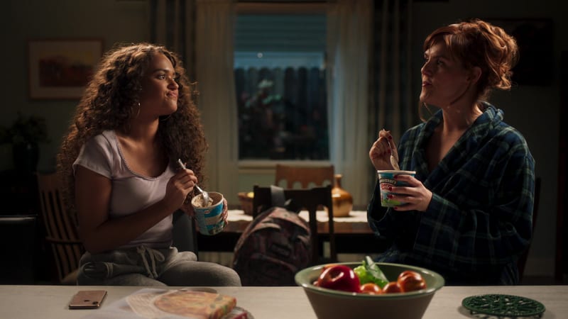 Two women eating ice cream and talking at the kitchen table