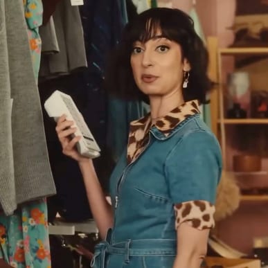 A woman in a vintage shop holding a Clover device