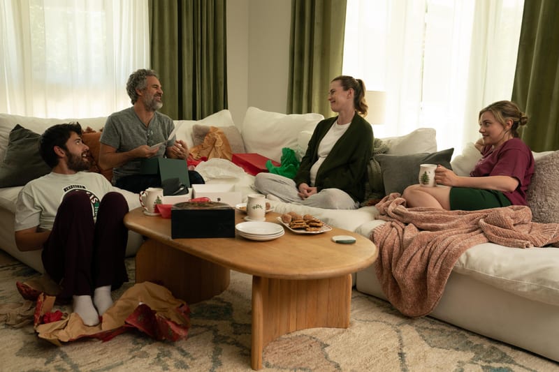 The family on a sectional sofa surrounded by opened gifts