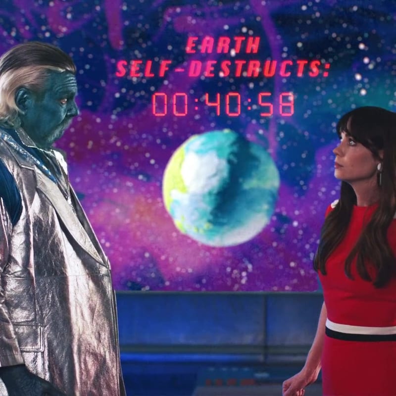 A blue alien man and a woman in red facing each other with a countdown clock reading Earth self-destructs