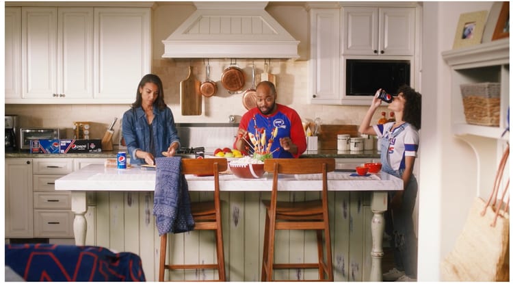 A miniature Giants player figure dancing on a kitchen counter beside a Pepsi can