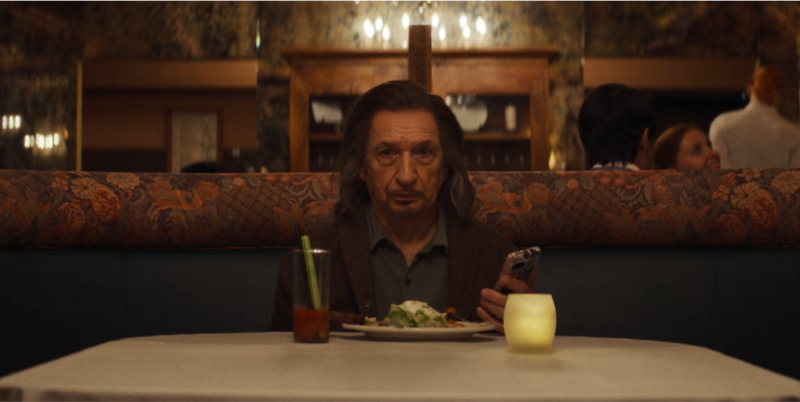 An older man seated in a restaurant booth
